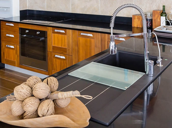 Angle view of kitchen sink with silver faucet in kitchen room, m