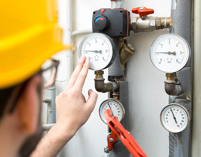 maintenance - technician checking pressure meters for house heat